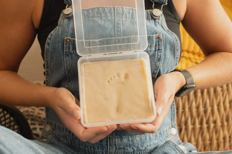 Image: parent using impression kit with baby